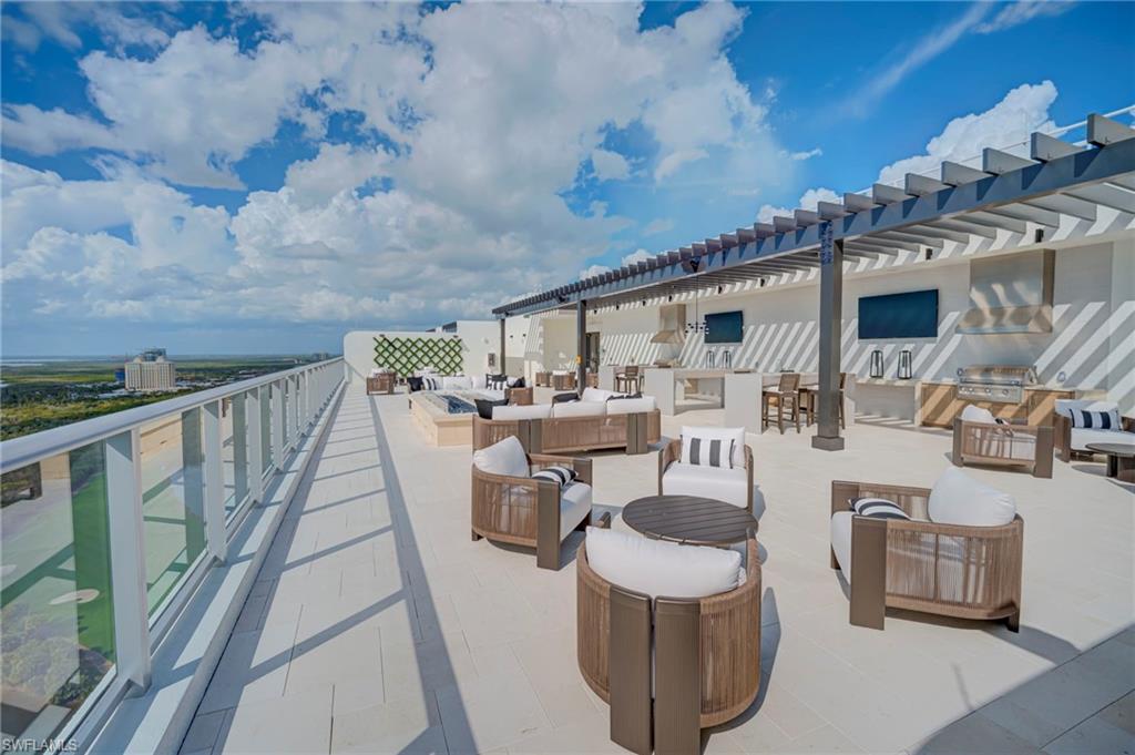 rooftop- featuring exterior kitchen, an outdoor lounge area with bar, and a pergola