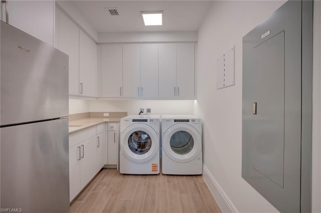Laundry area with light wood-style flooring and washing machine and dryer