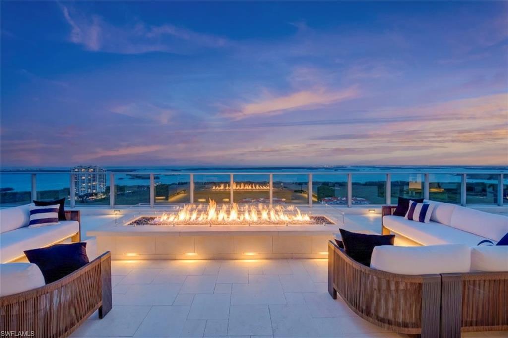 rooftop at dusk featuring an outdoor living space with a fire pit