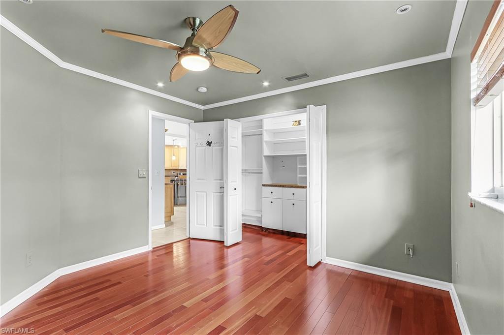 Unfurnished bedroom featuring ornamental molding, a ceiling fan, dark wood-type flooring, recessed lighting, and a closet