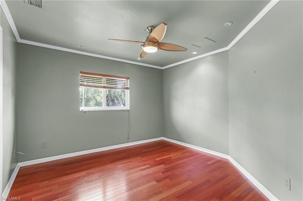 Unfurnished room featuring crown molding, hardwood / wood-style floors, and ceiling fan