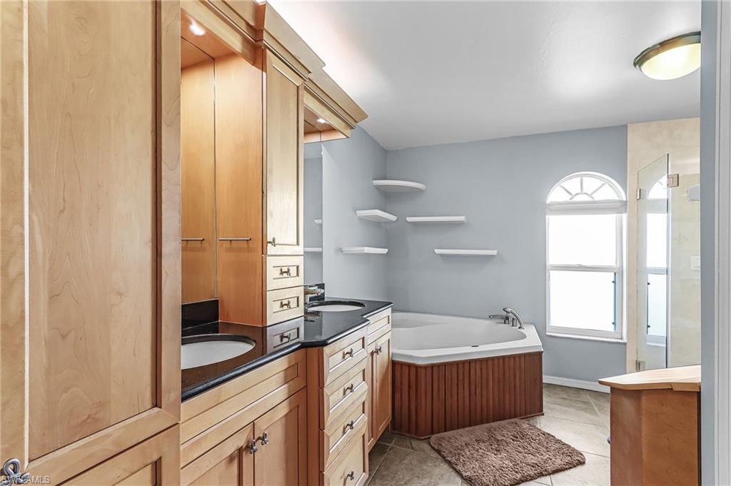 Full bath with vanity, a stall shower, and a bath