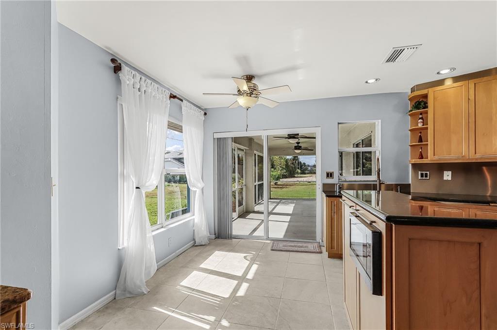 Kitchen with open shelves, a ceiling fan, recessed lighting, wood finish cabinets, and light tile patterned floors