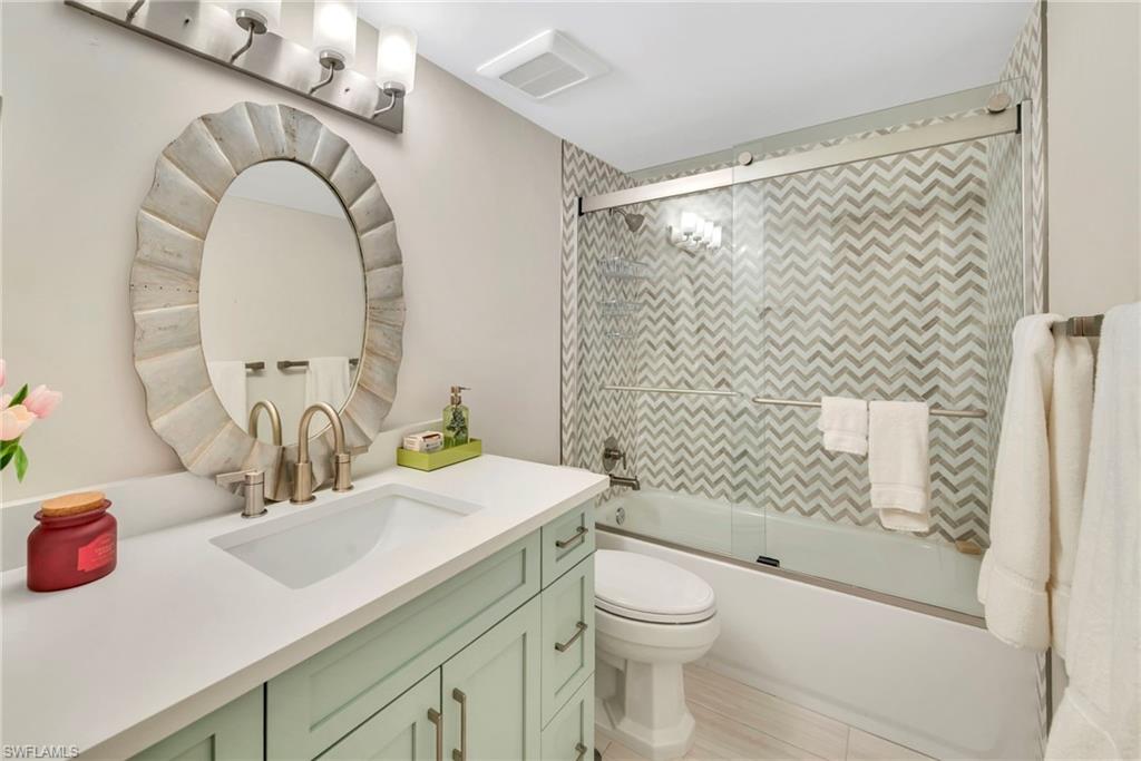 Full bath featuring vanity and combined bath / shower with glass door