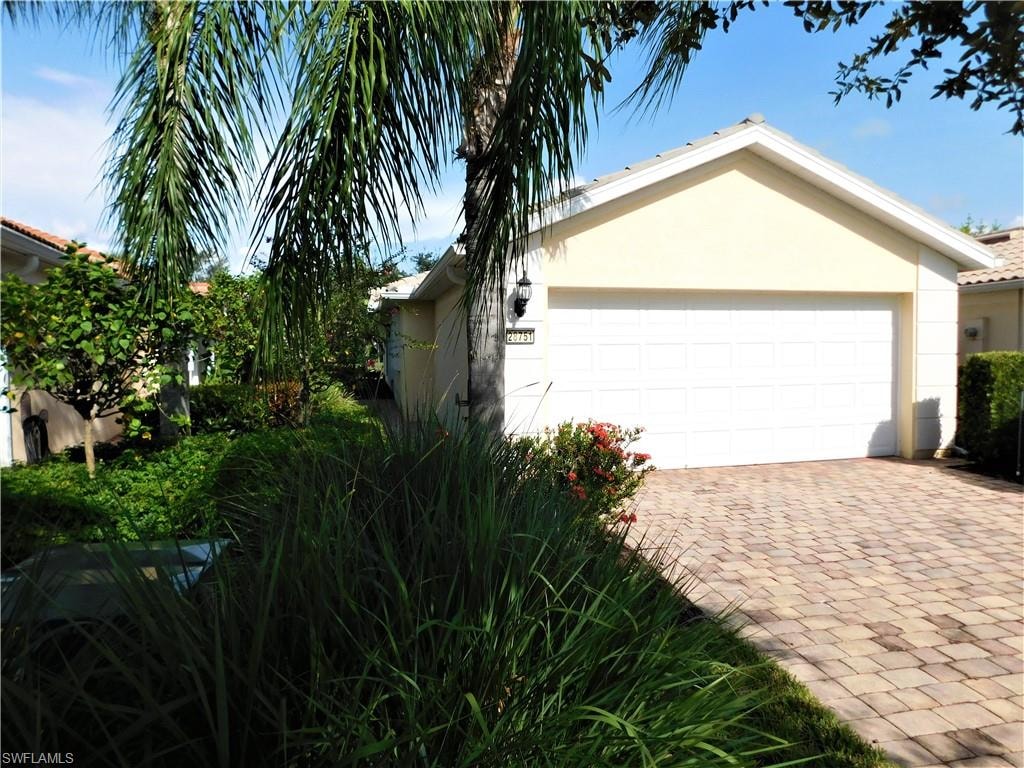 View of home's exterior featuring stucco siding, driveway, and a garage
