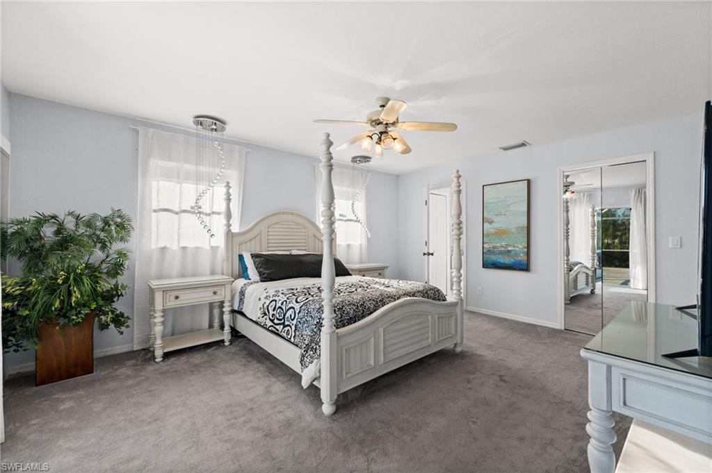 Bedroom with carpet, multiple windows, and ceiling fan