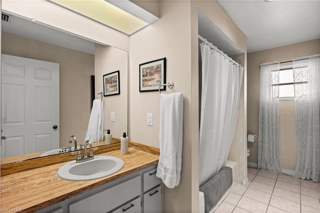 Bathroom with vanity, light tile patterned floors, and shower / bath combo