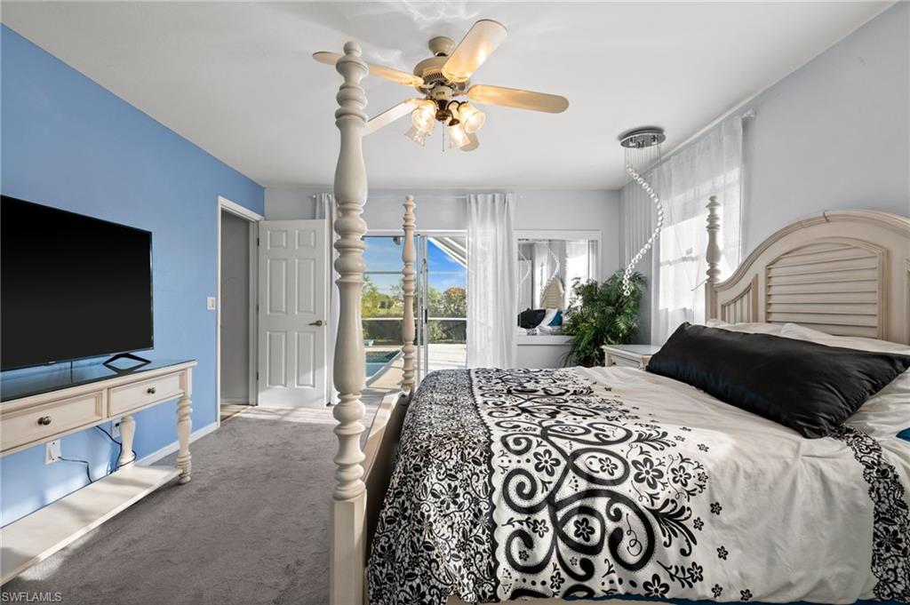 Carpeted bedroom with access to exterior and ceiling fan