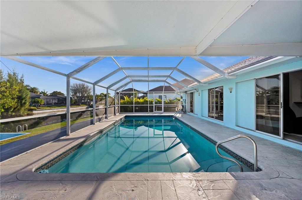 Swimming pool with a sunroom, screen enclosure, and a patio