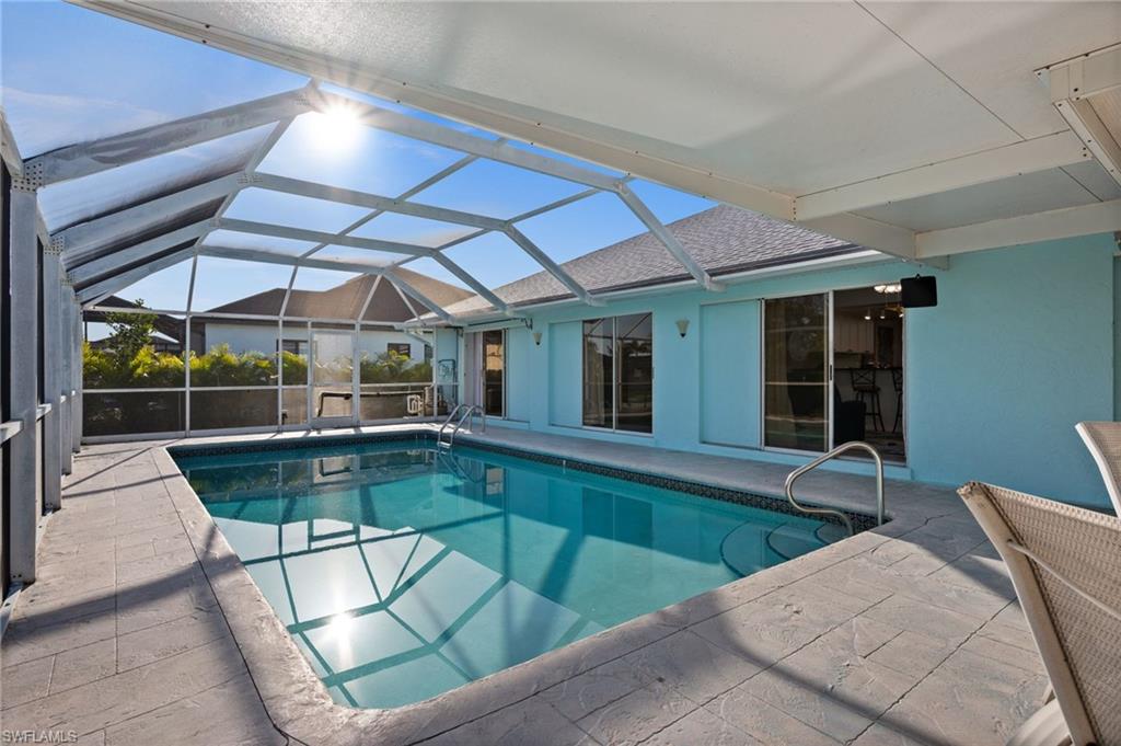 Swimming pool featuring a patio area, a lanai, screen cage