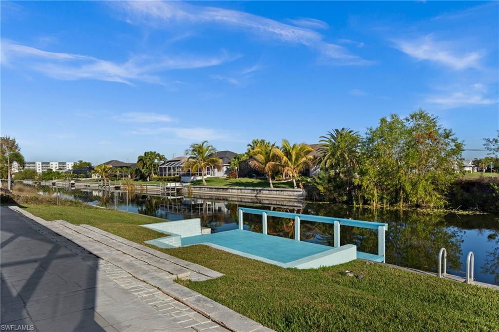 Dock area featuring a water view and a lawn