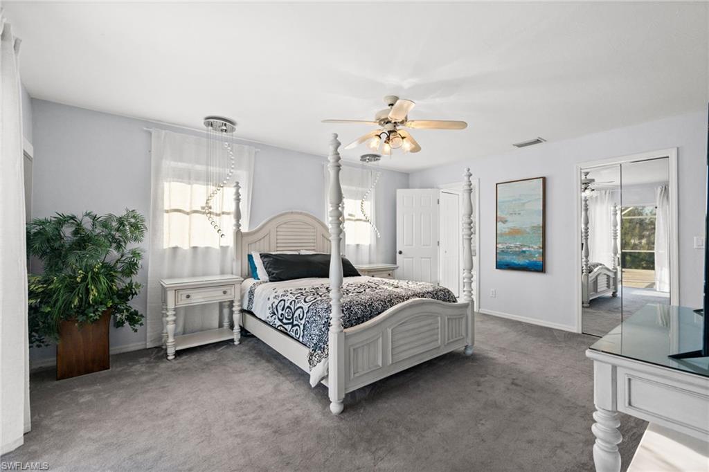 Bedroom with carpet, ceiling fan, and multiple windows
