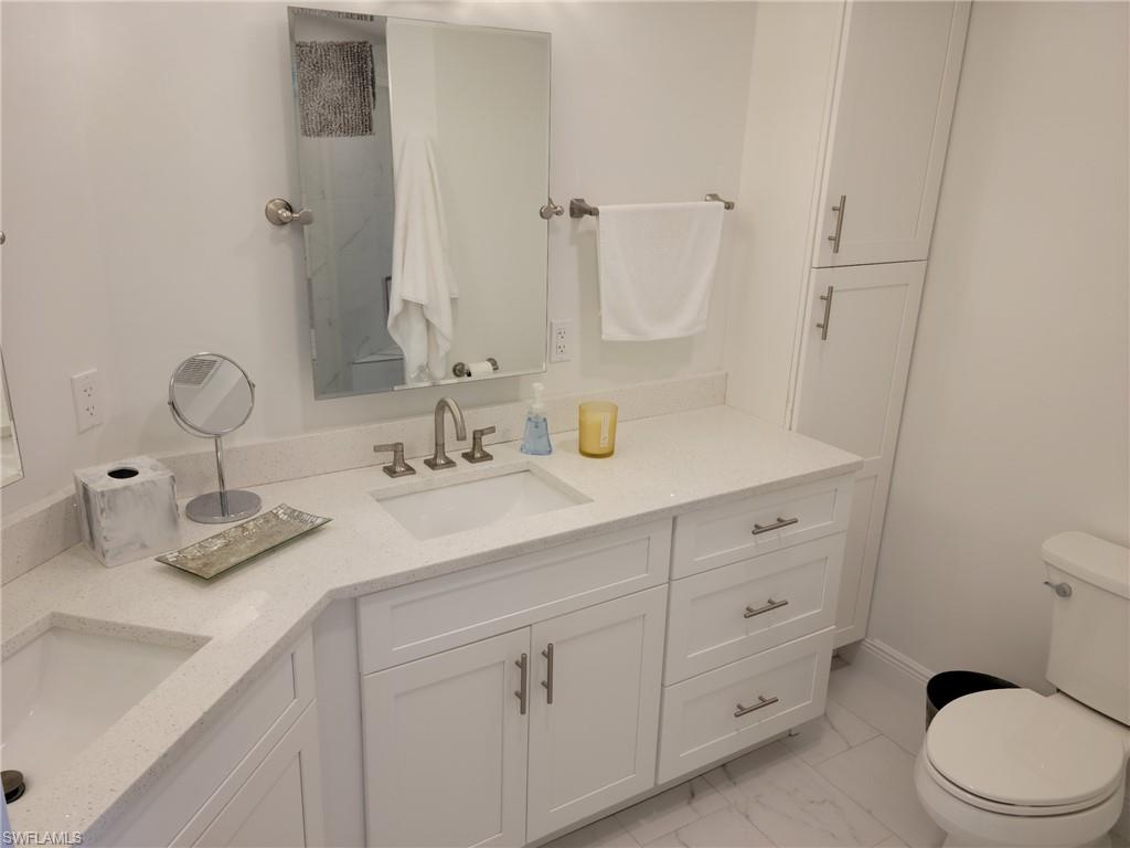 Master bath with dual sinks, tile floors, linen cabinet, light, right and neutral.