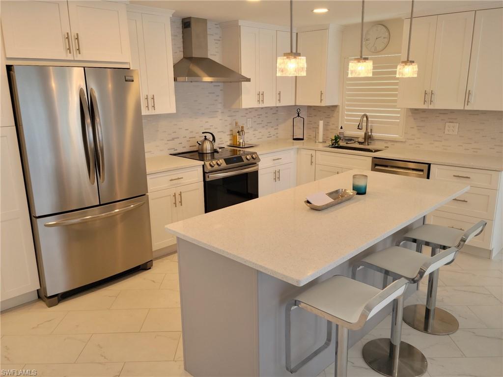 Light, bright and open kitchen with stainless steel appliances, tile backsplash, quart tops, breakfast bar.