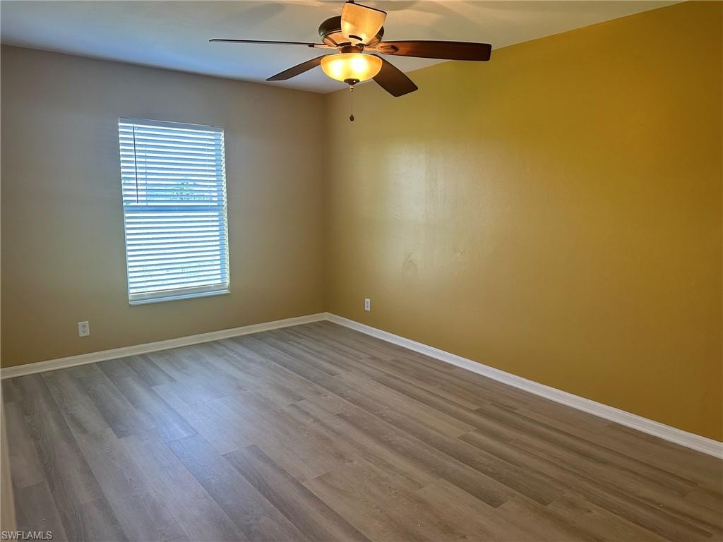 Unfurnished room featuring a ceiling fan and wood finished floors