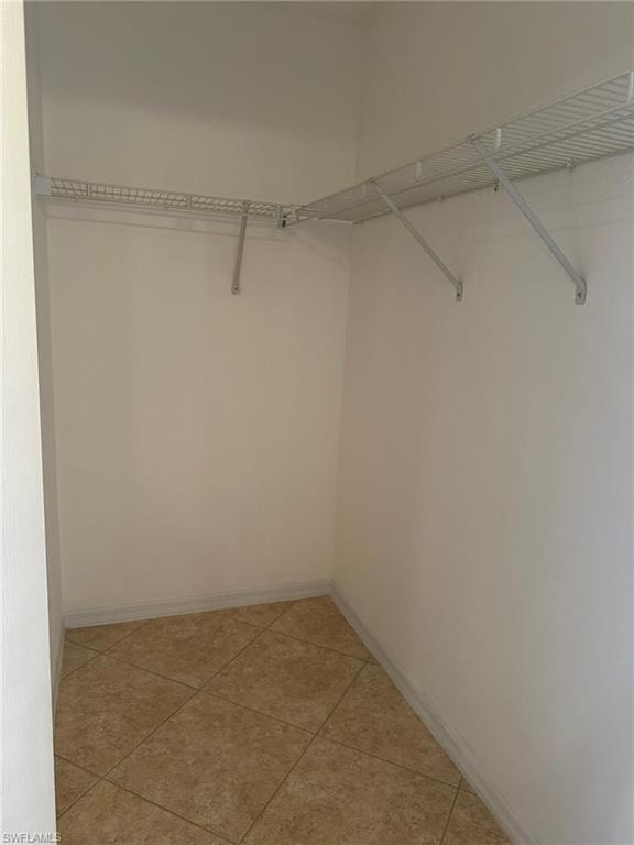 Walk in closet with light tile patterned floors