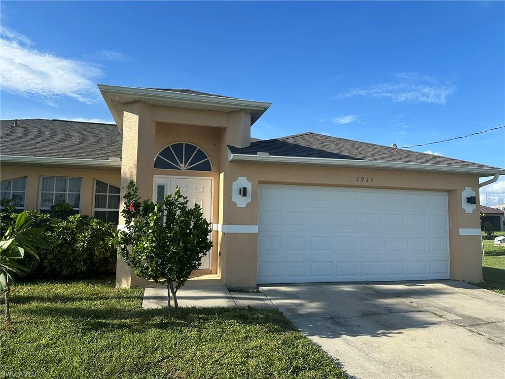 Ranch-style house with stucco siding, a garage, and driveway