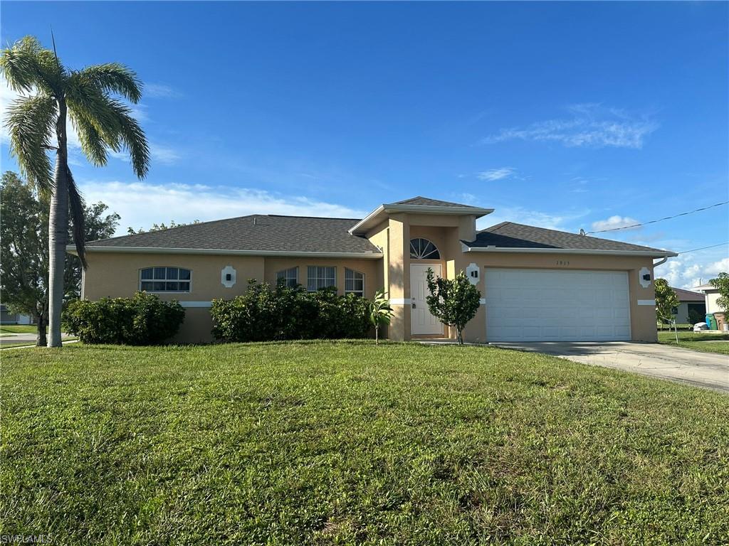 View of front of home featuring stucco siding, driveway, a front lawn, and a garage