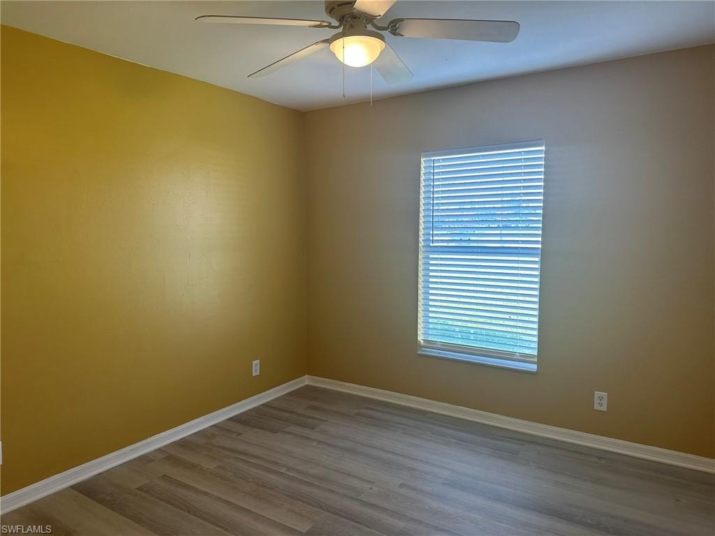 Empty room with ceiling fan and wood finished floors