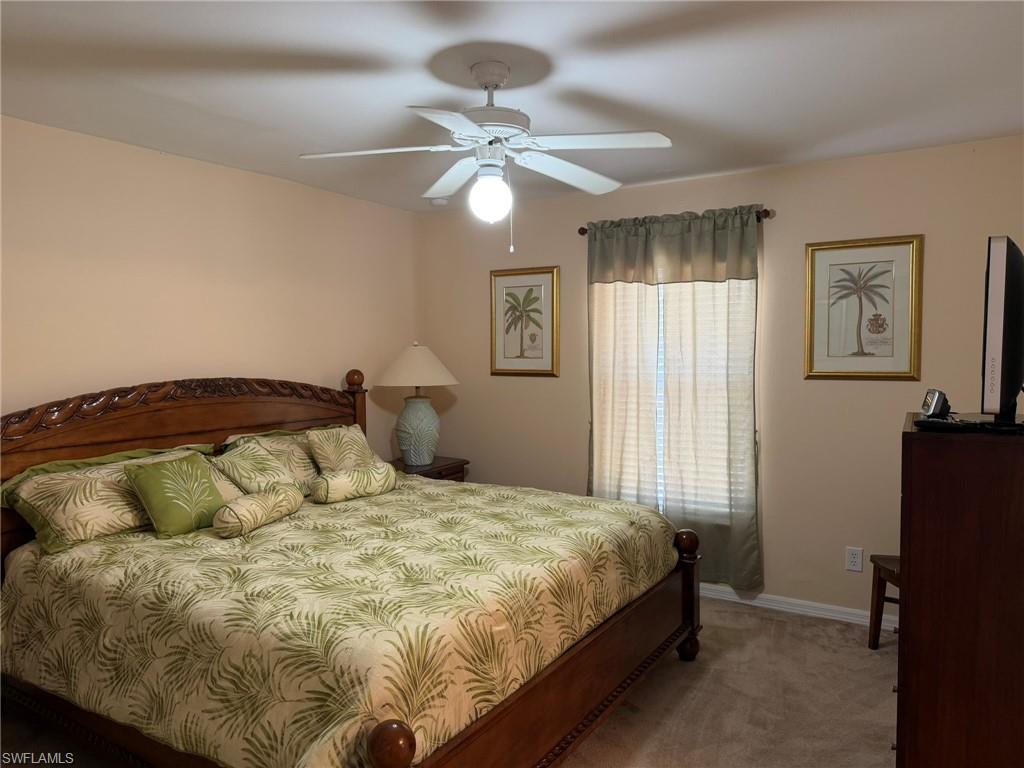Carpeted bedroom featuring baseboards and ceiling fan