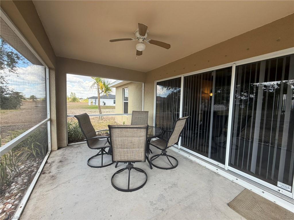 View of patio / terrace featuring ceiling fan, outdoor dining space, and a sunroom