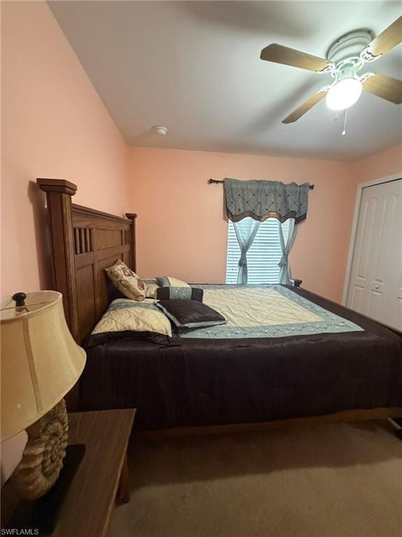 Carpeted bedroom with ceiling fan and a closet