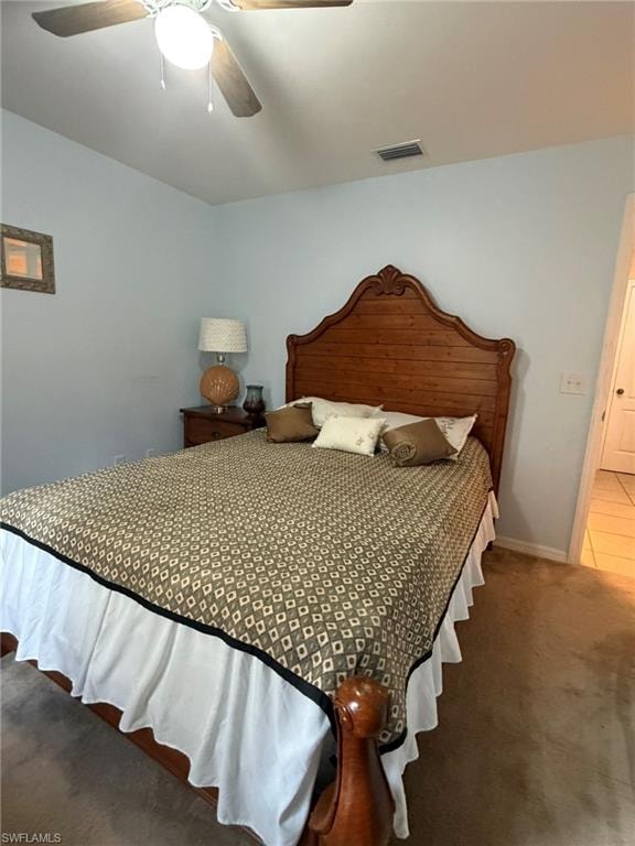 Carpeted bedroom with ceiling fan and baseboards
