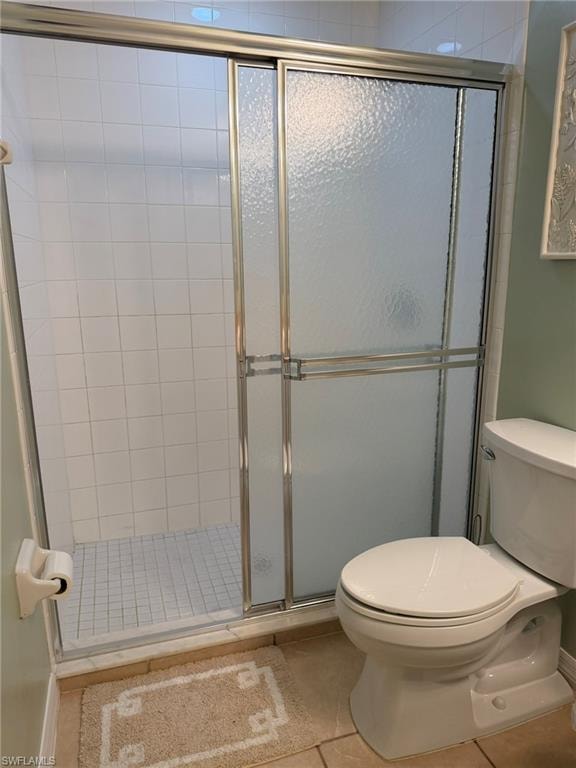 Bathroom featuring a shower stall and light tile patterned flooring