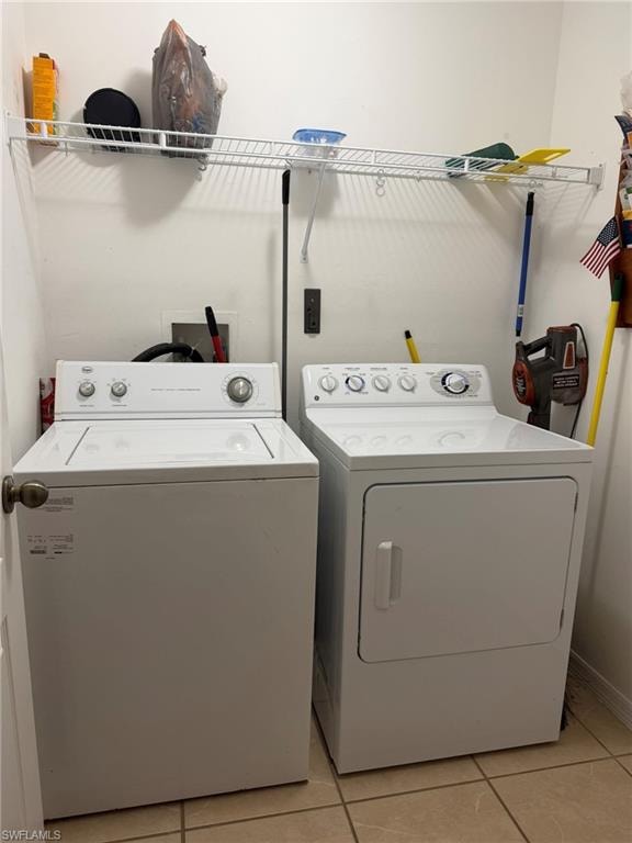 Laundry area featuring light tile patterned floors and separate washer and dryer