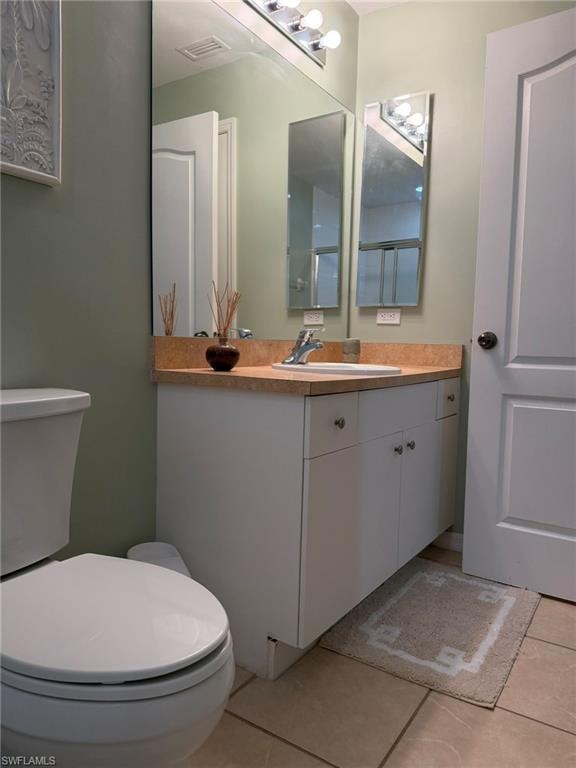 Half bathroom with vanity and light tile patterned flooring