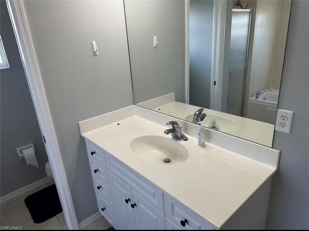 Bathroom featuring vanity, a stall shower, and a bath