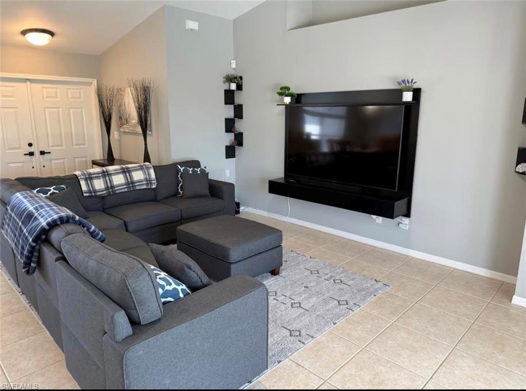 Living room with light tile patterned flooring and baseboards