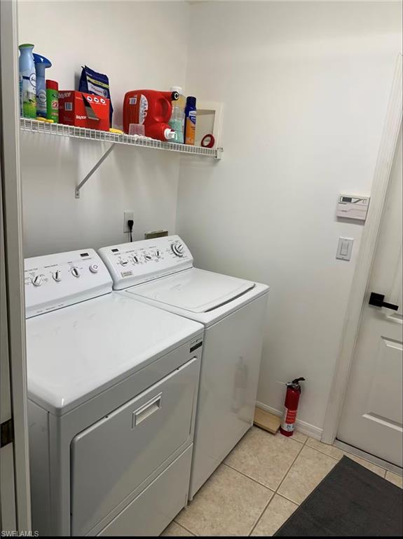 Laundry area with light tile patterned floors and independent washer and dryer