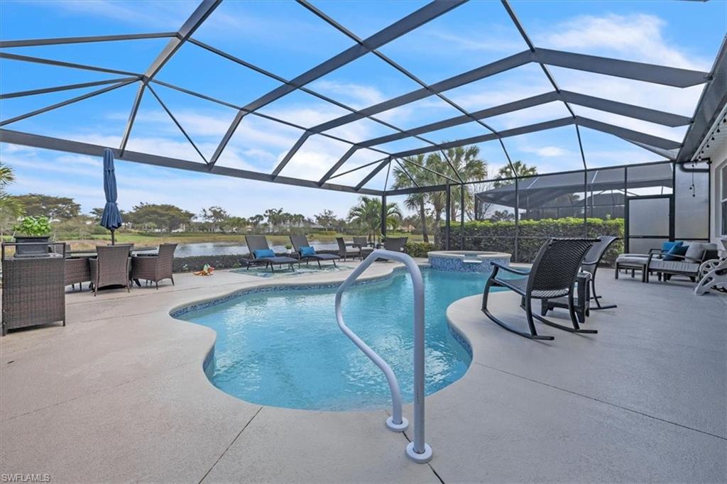 Integrated pool / hot tub with a sunroom, glass enclosure, a patio, and outdoor dining area