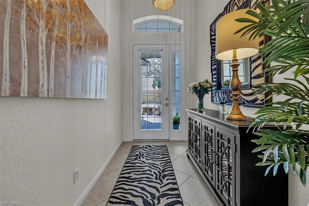Entryway with a textured wall and light tile patterned floors