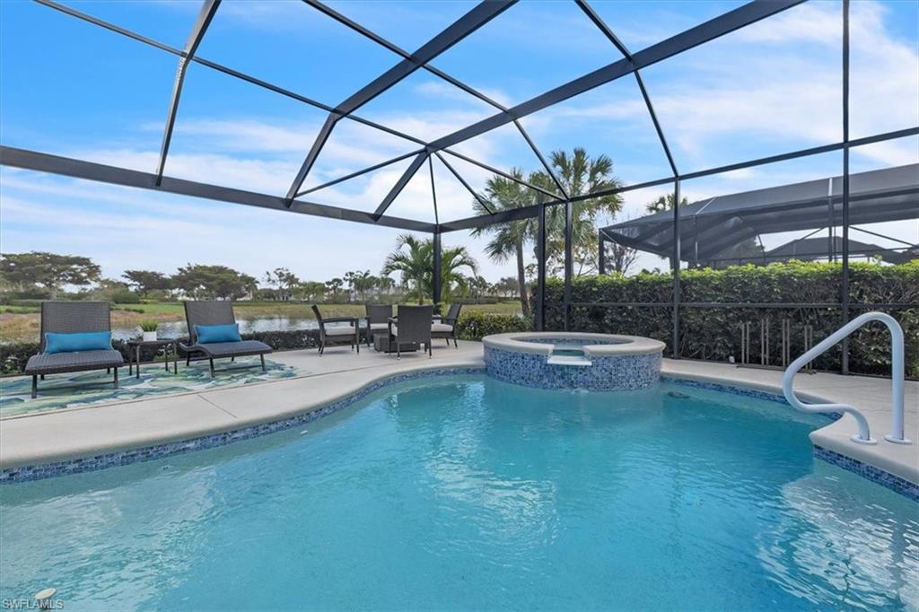 Integrated pool / spa featuring glass enclosure, a sunroom, and a patio