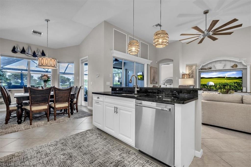 Kitchen featuring white cabinetry, dishwasher, a ceiling fan, light tile patterned floors, and open floor plan