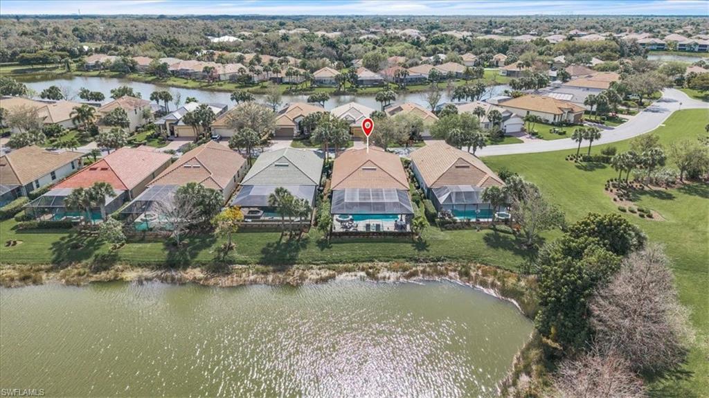 Aerial view of residential area featuring a nearby body of water