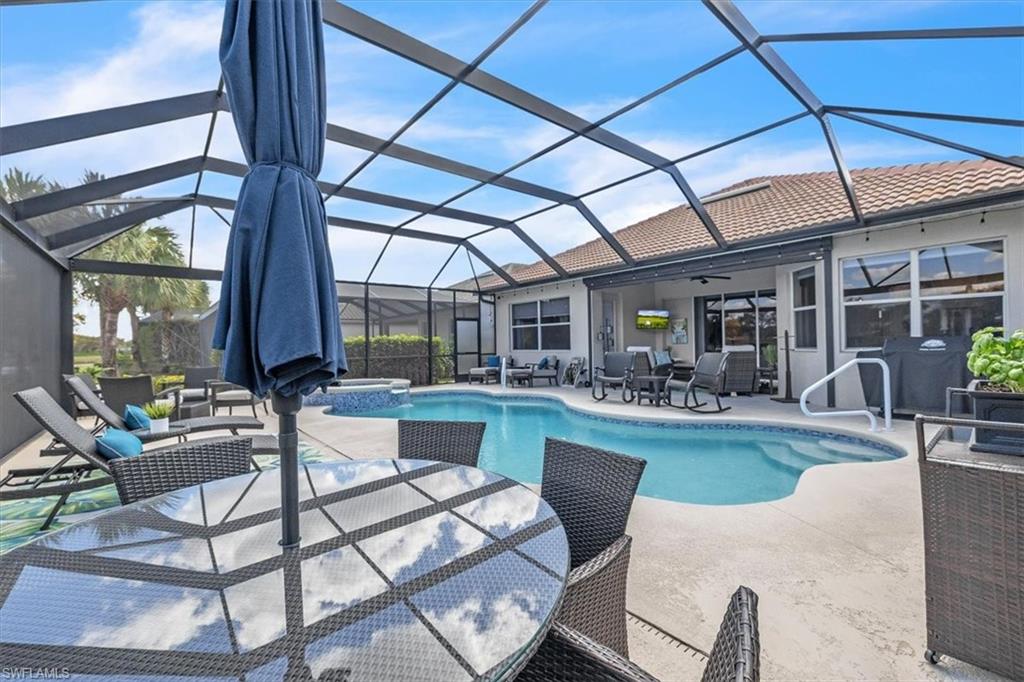 Integrated pool / hot tub with a sunroom, an outdoor living / dining area, a patio area, and a lanai
