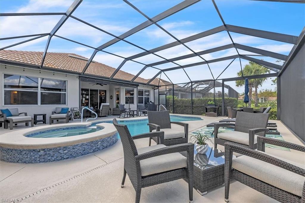 View of patio with outdoor seating, a sunroom, a ceiling fan, and glass enclosure
