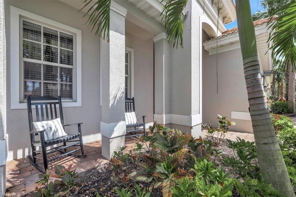 Doorway to property with stucco siding, a tile roof, and covered porch