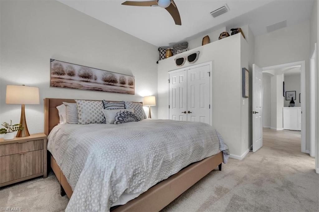 Bedroom featuring light carpet, a closet, and ceiling fan