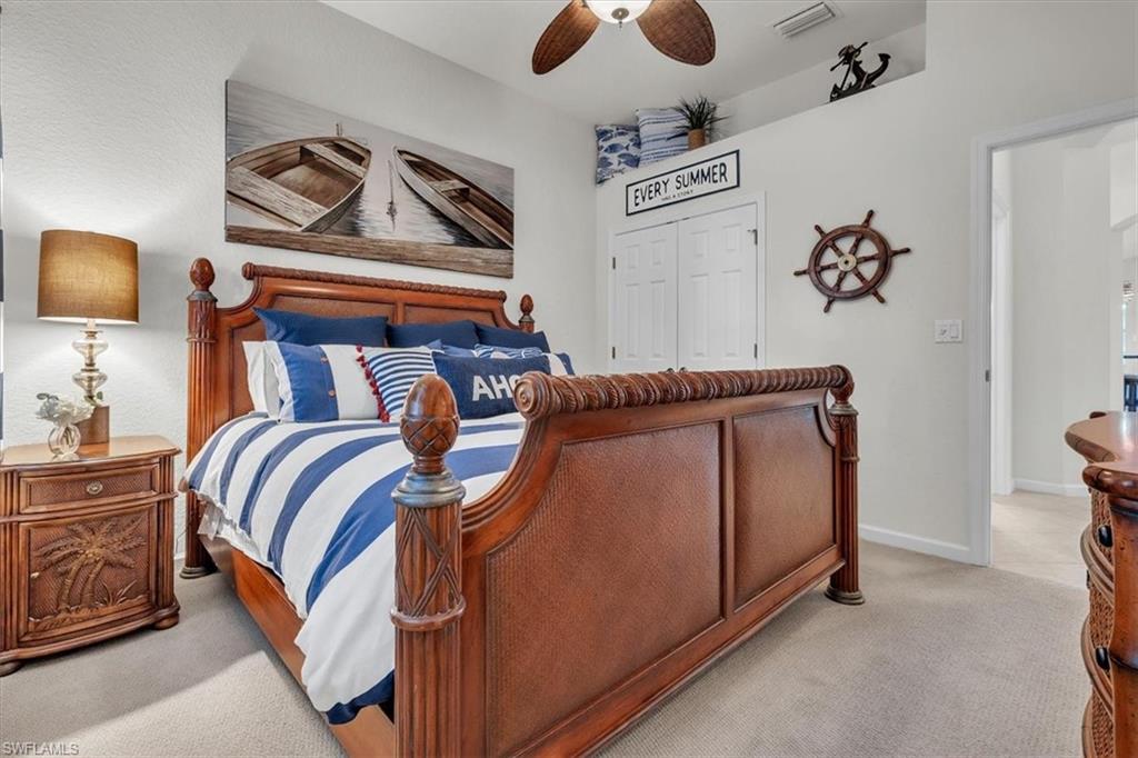 Bedroom with light carpet, a closet, and a ceiling fan