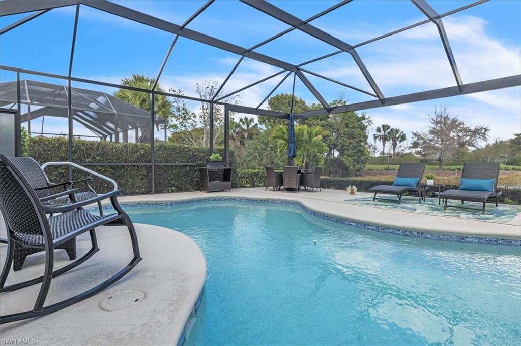 Swimming pool with a lanai, a sunroom, outdoor dining area, and a patio area
