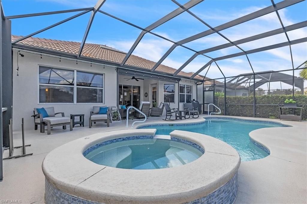 Integrated pool / spa featuring a sunroom, a patio, and glass enclosure