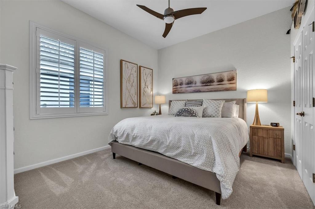 Bedroom with ceiling fan and light colored carpet
