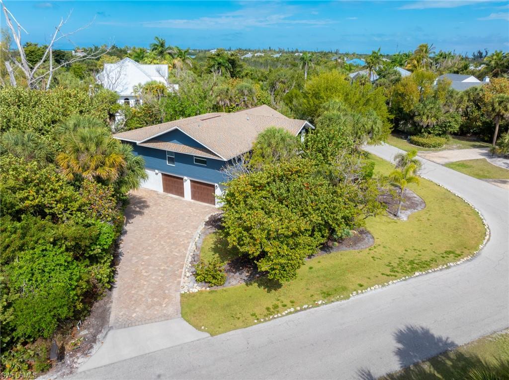 Aerial view of property and surrounding area featuring a tree filled landscape