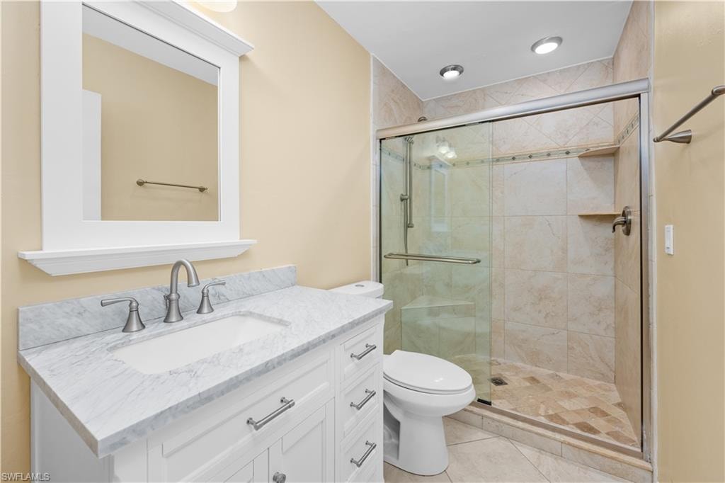 Full bath featuring vanity, a stall shower, and light tile patterned floors