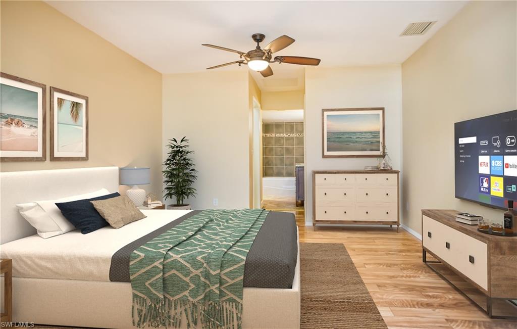 Bedroom featuring light wood finished floors, connected bathroom, and ceiling fan