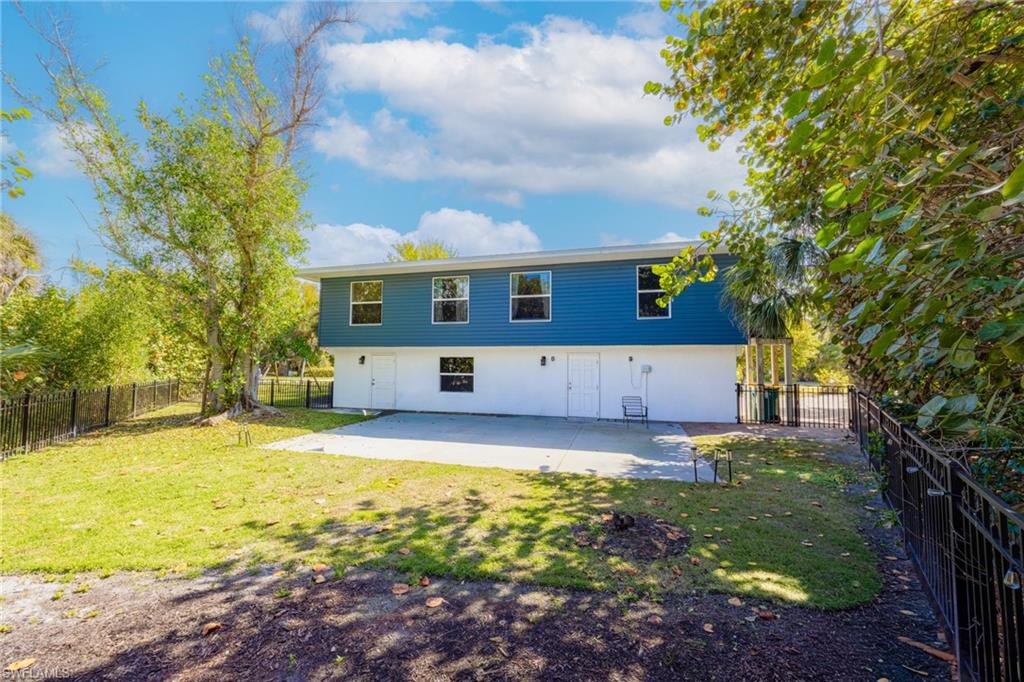 Rear view of house with a fenced backyard and stucco siding